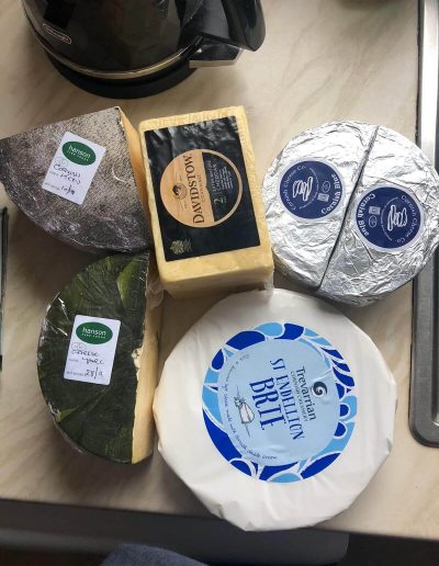 Suppliers & Producers - Image of cheeses from Hanson Fine Foods on a wooden tabletop - Duchy Chef Cornwall